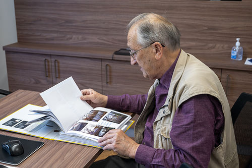 Wieland Liebusch blättert ein Fotoalbum durch
